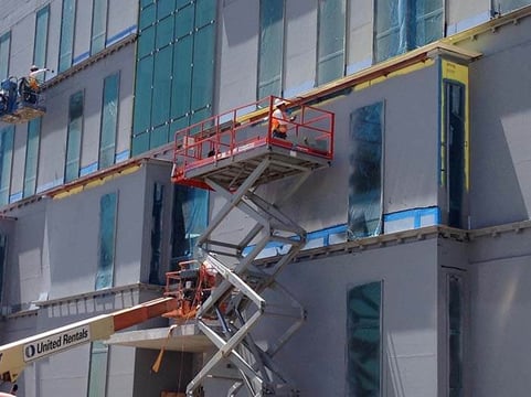 Chamberlin's employee on the side of highrise building working on energy improvements