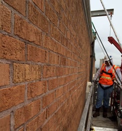 Chamberlin contractors repair the original wall of bricks to the Hallmark building