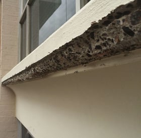 Outside view of an angled view of a crack in a white window sill